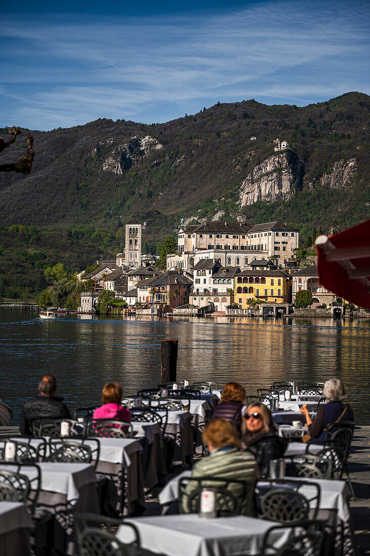 Blick auf Isola San Giulio vom Hafen Orta San Giulio mit Straßencafe, Piazza Motta, Gemeinde Orta San Giulio, Ortasee Lago d’Orta, Region Piemont, Italien