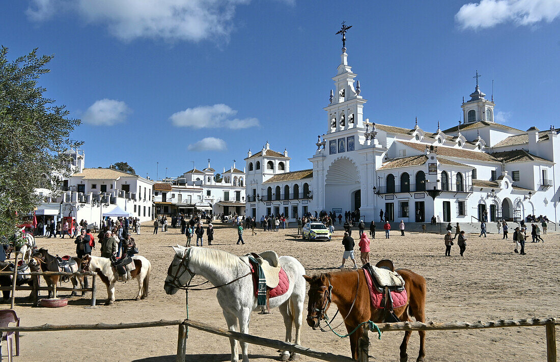 Pferde und Menschen am Platz vor der Pilgerkirche Ermita del Rocío im Donana Nationalpark, El Rocio,  Provinz Huelva, Andalusien, Spanien