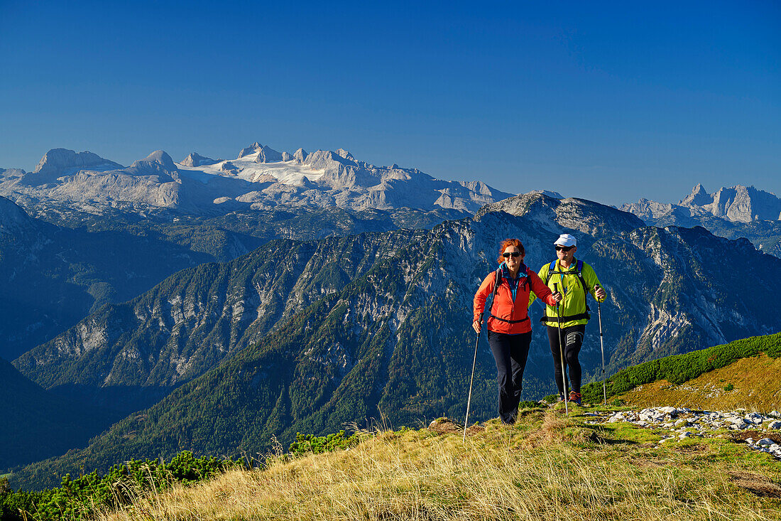  Man and woman hiking with Dachstein group in the background, from Loser, Totes Gebirge, Salzkammergut, Styria, Austria 