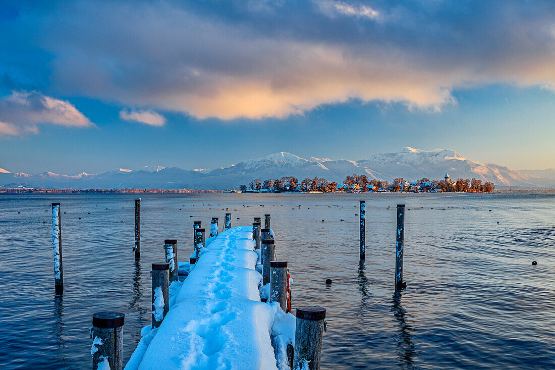 Verschneiter Steg am Chiemsee mit Fraueninsel und Chiemgauer Alpen im Hintergrund, Chiemsee, Chiemgauer Alpen, Oberbayern, Bayern, Deutschland