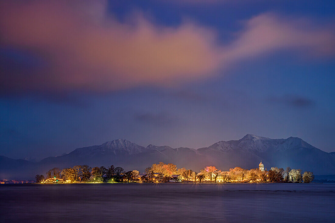  Chiemsee and snow-covered, illuminated Fraueninsel with Chiemgau Alps in the background, Chiemsee, Chiemgau Alps, Upper Bavaria, Bavaria, Germany 