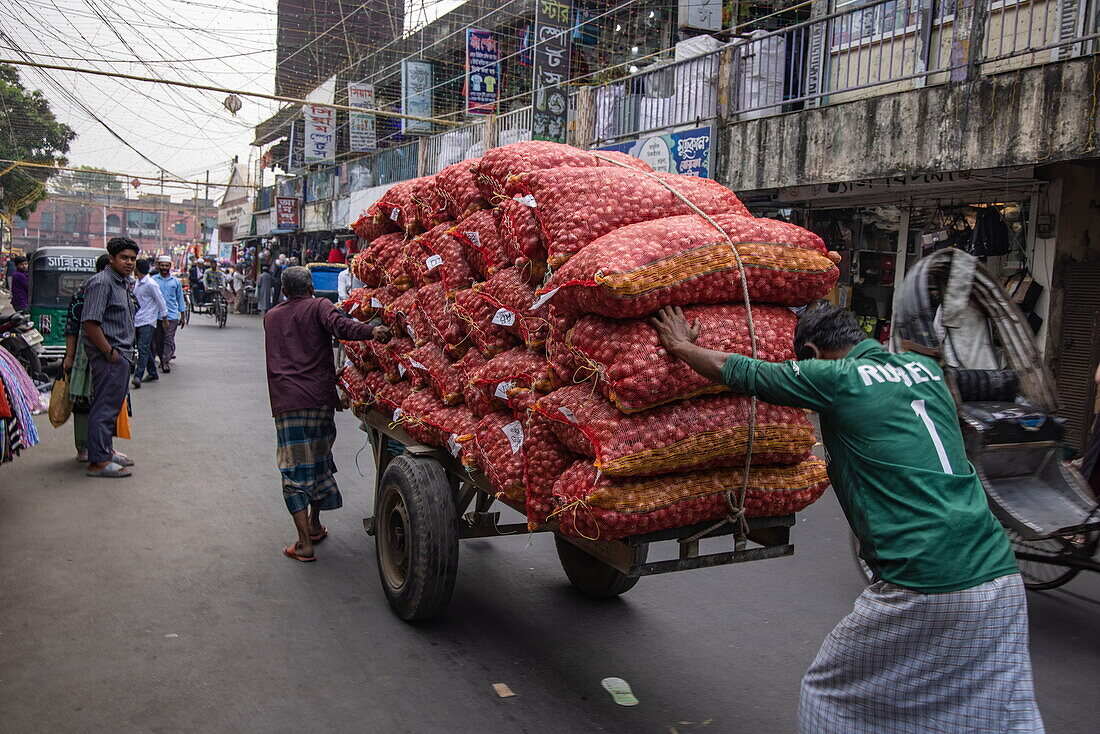 Men pull and push a cart loaded with sacks of onions through downtown Barisal (Barishal), Barisal District, Bangladesh, Asia 