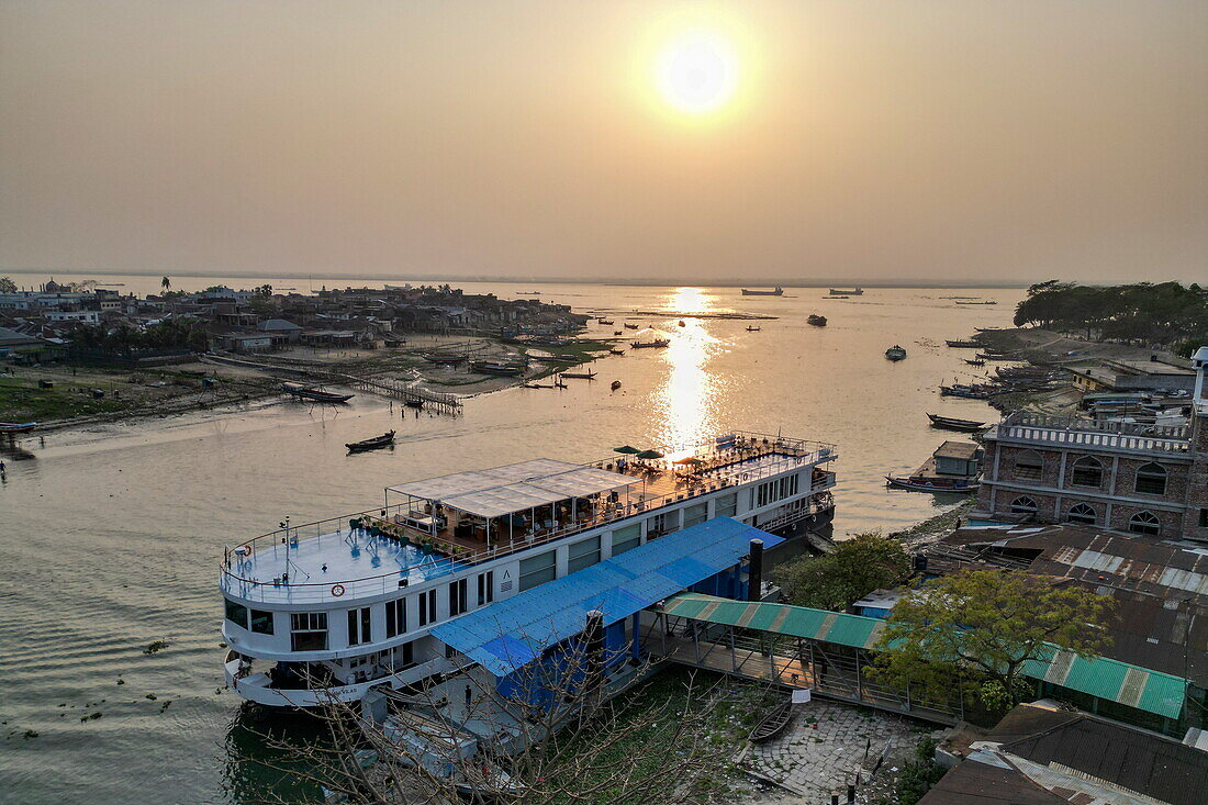 Aerial of river cruise ship RV Thurgau Ganga Vilas (Thurgau Travel) moored along Dakatiya river at sunset, Chandpur, Chandpur District, Bangladesh, Asia