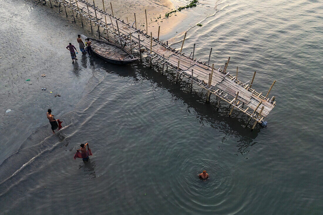 Luftaufnahme vom Bambussteg und Menschen im Wasser am Fluss Dakatiya, Chandpur, Distrikt Chandpur, Bangladesch, Asien