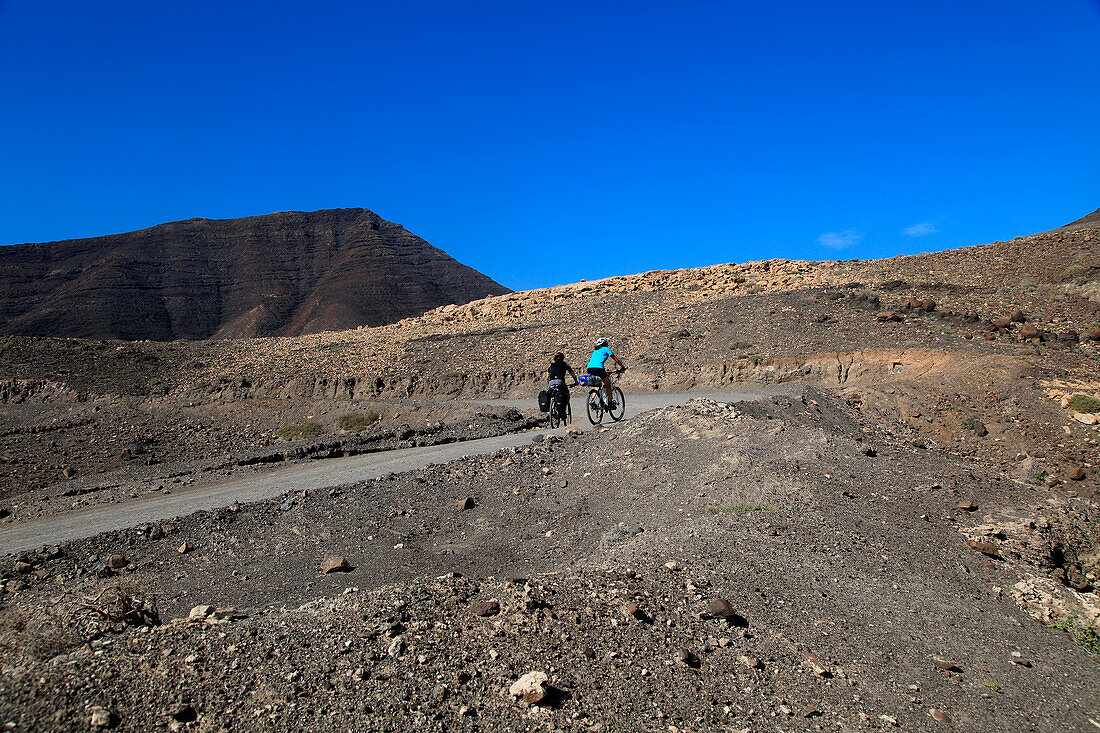 Cycling in barren landscape of Jandia peninsula Fuerteventura, Canary Islands, Spain