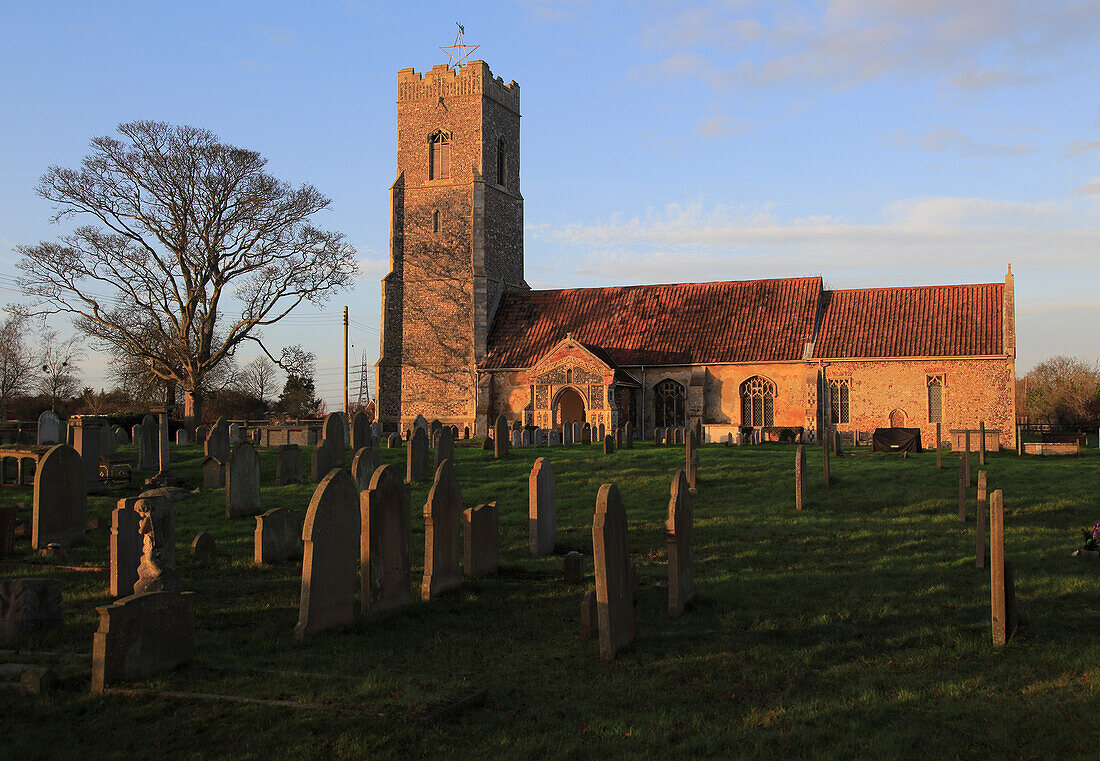 Am späten Nachmittag fällt goldenes Winterlicht auf die Kirche St. Johannes der Täufer, Snape, Suffolk, England, Großbritannien