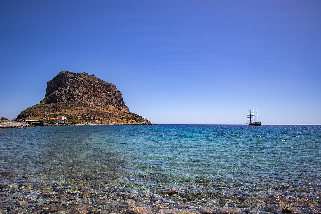  Monemvasia Island and sailing cruise ship Running on Waves (M&#39;Ocean) anchored in the bay, Monemvasia, Peloponnese, Greece, Europe 