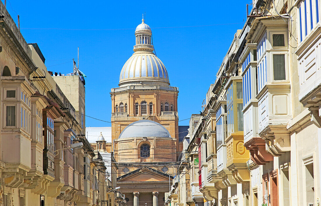 Traditional houses with balconies dome of Paola parish church, Tarxien town, near Valletta, Malta