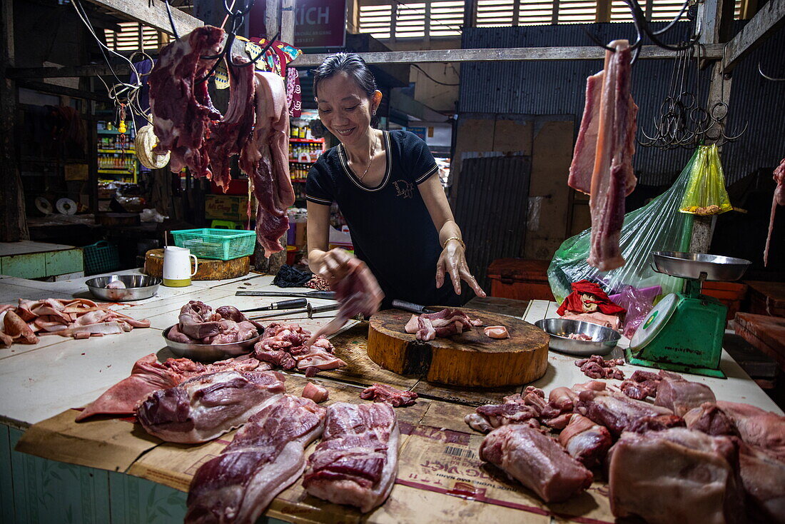 Fröhliche einheimische Metzgerin auf dem lokalen Markt, Tan Chau (Tân Châu), An Giang, Vietnam, Asien