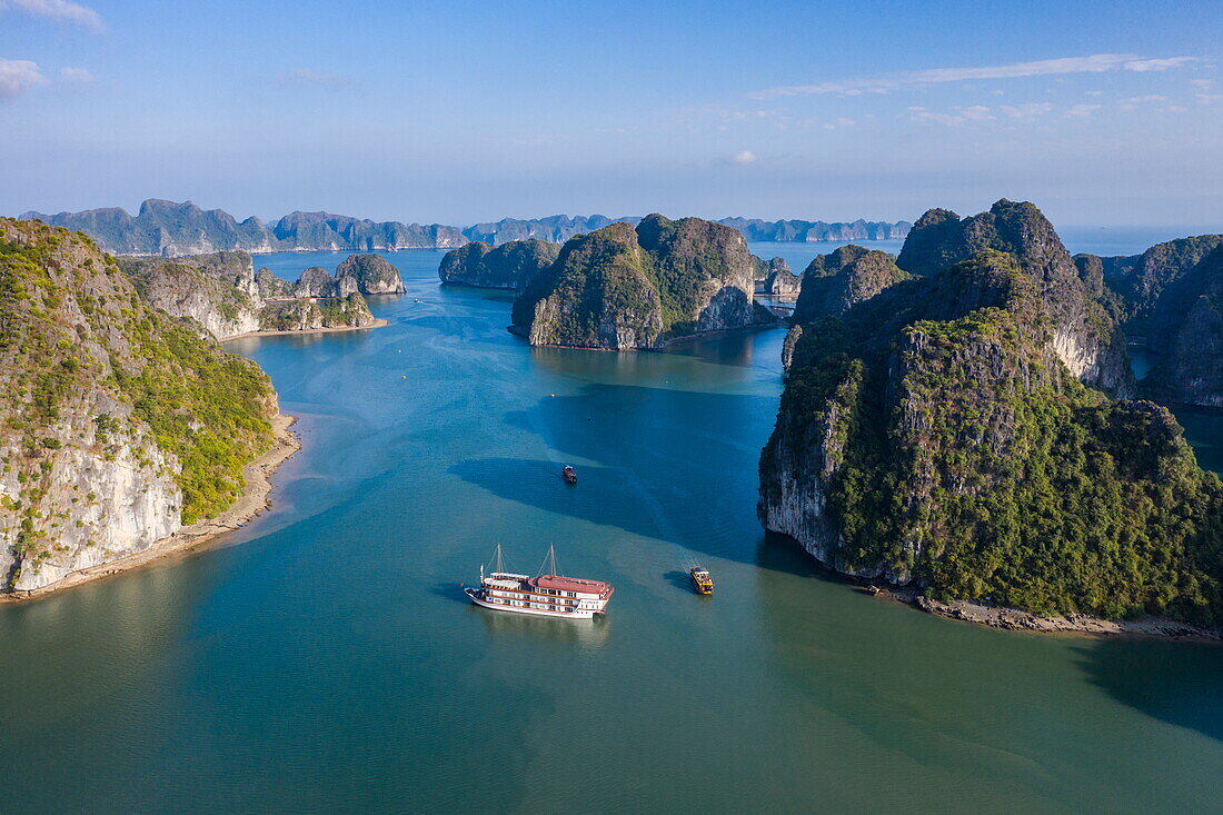 Luftaufnahme des Kreuzfahrtschiffs Ginger (Heritage Line) in einer Bucht inmitten von Karstinseln, Lan Ha Bay, Haiphong, Südchinesisches Meer, Vietnam, Asien