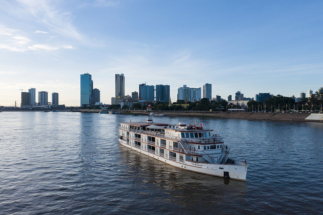  Aerial view of river cruise ship The Jahan (Heritage Line) on the Mekong River in front of the city skyline, Phnom Penh, Phnom Penh, Cambodia, Asia 