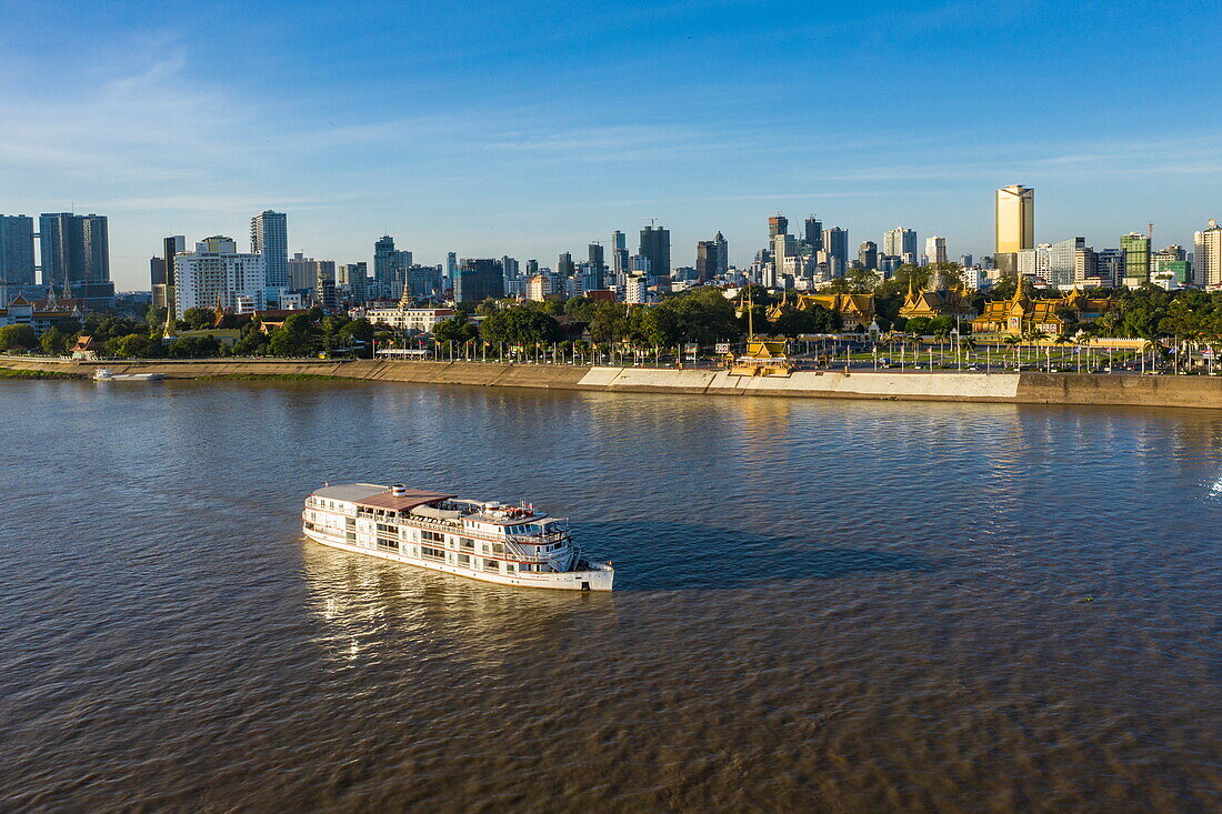 Luftaufnahme des Flusskreuzfahrtschiffs The Jahan (Heritage Line) auf dem Mekong mit Königspalast und Skyline der Stadt, Phnom Penh, Kambodscha, Asien