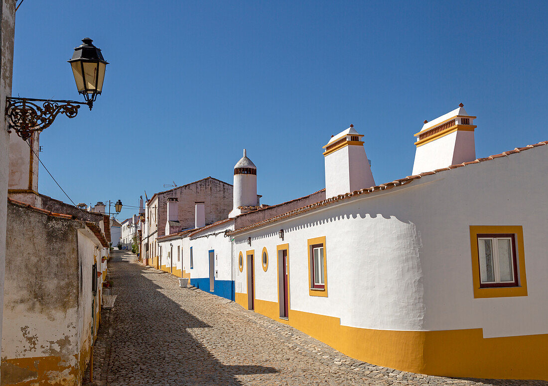 Traditionelle Architektur, große Schornsteine in weiß getünchten Häusern und Straßen im kleinen ländlichen Siedlungsdorf Terena, Alentejo Central, Portugal, Südeuropa