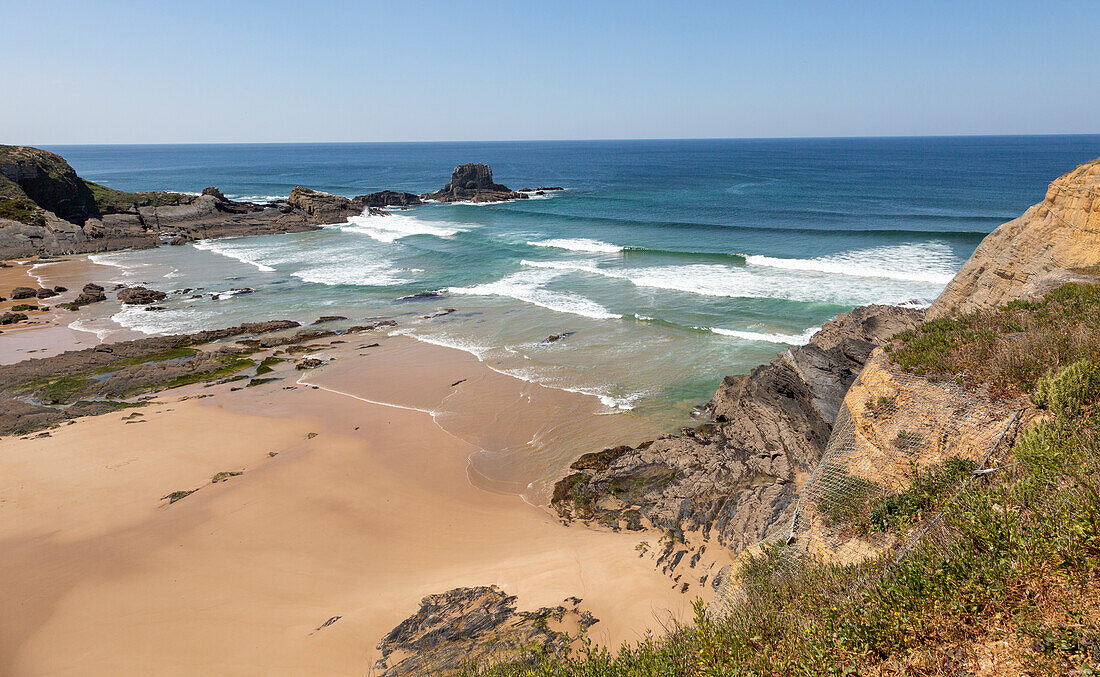 Sandy Carvalhal beach in bay between rocky headlands at Parque Natural do Sudoeste Alentejano e Costa Vicentina, Costa Vicentina natural park, near Brejão, south west Alentejo, Alentejo Littoral, Portugal, Southern Europe