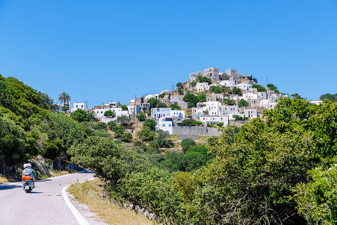  Mountain road with scooter and mountain village Emborió (Emporios, Emporio) on the island of Nissyros (Nisyros, Nissiros, Nisiros) in Greece 