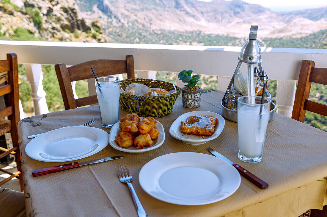  fried stuffed zucchini flowers (kolokitholoulouda) and baked feta cheese with honey and sesame, served with almond water (almond milk, soumáda), served on the balcony of the tavern To Balkóni tou Emboriou in Emborió overlooking the caldera on the island of Nissyros (Nisyros, Nissiros, Nisiros) in Greece 