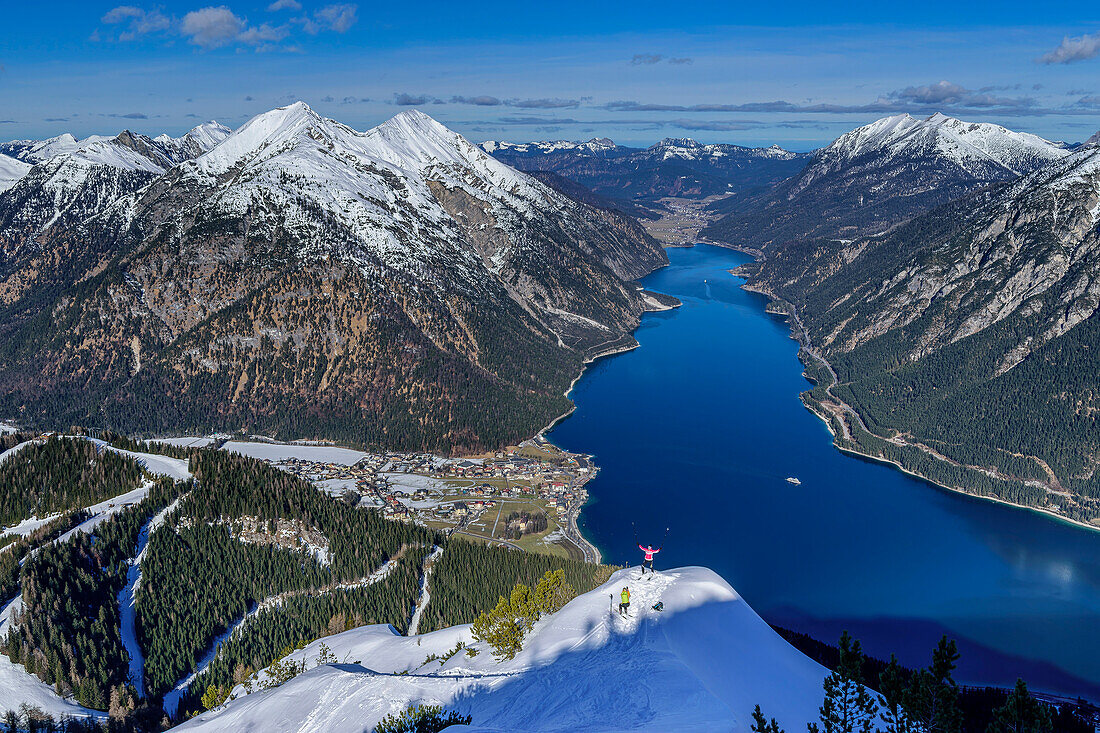  Two people on ski tour standing on snow peak above Lake Achensee, at Bärenkopf, Karwendel, Tyrol, Austria 