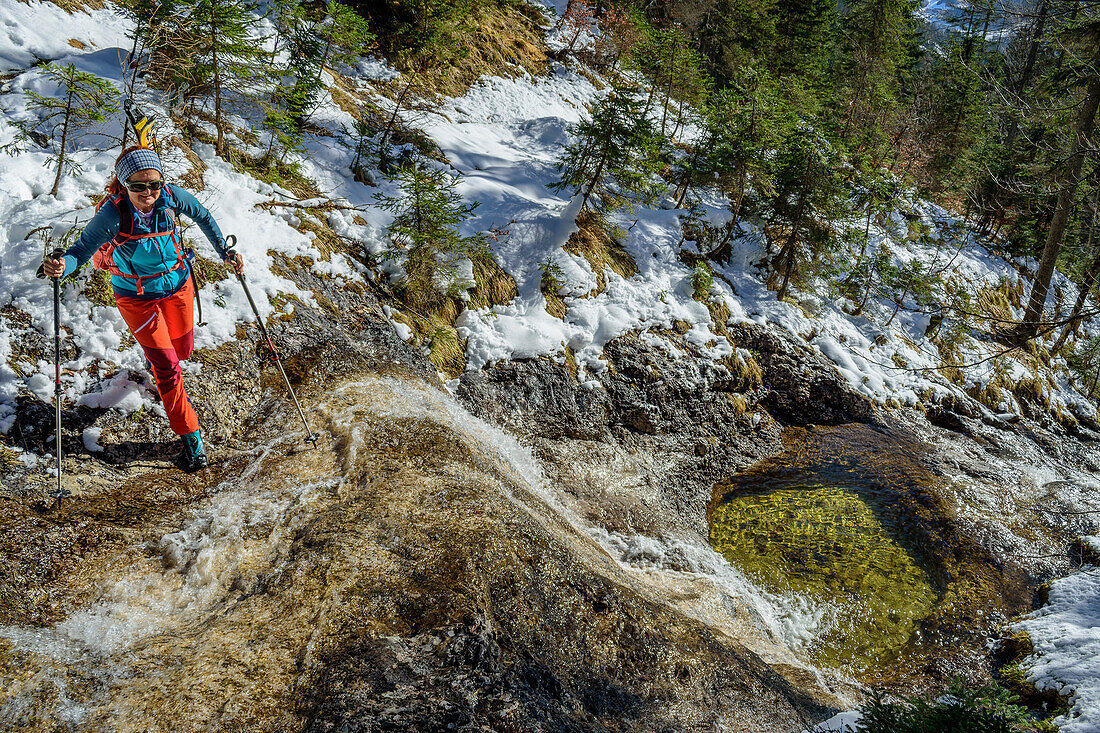  Woman on ski tour crossing a torrent, Kirtagskar, Totes Gebirge, Upper Austria, Austria 