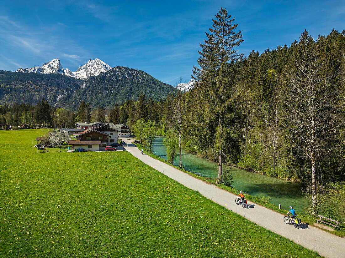  Man and woman cycling along the Ramsauer Ache on the Lake Constance-Königssee cycle path, Watzmann in the background, Berchtesgaden, Upper Bavaria, Bavaria, Germany 