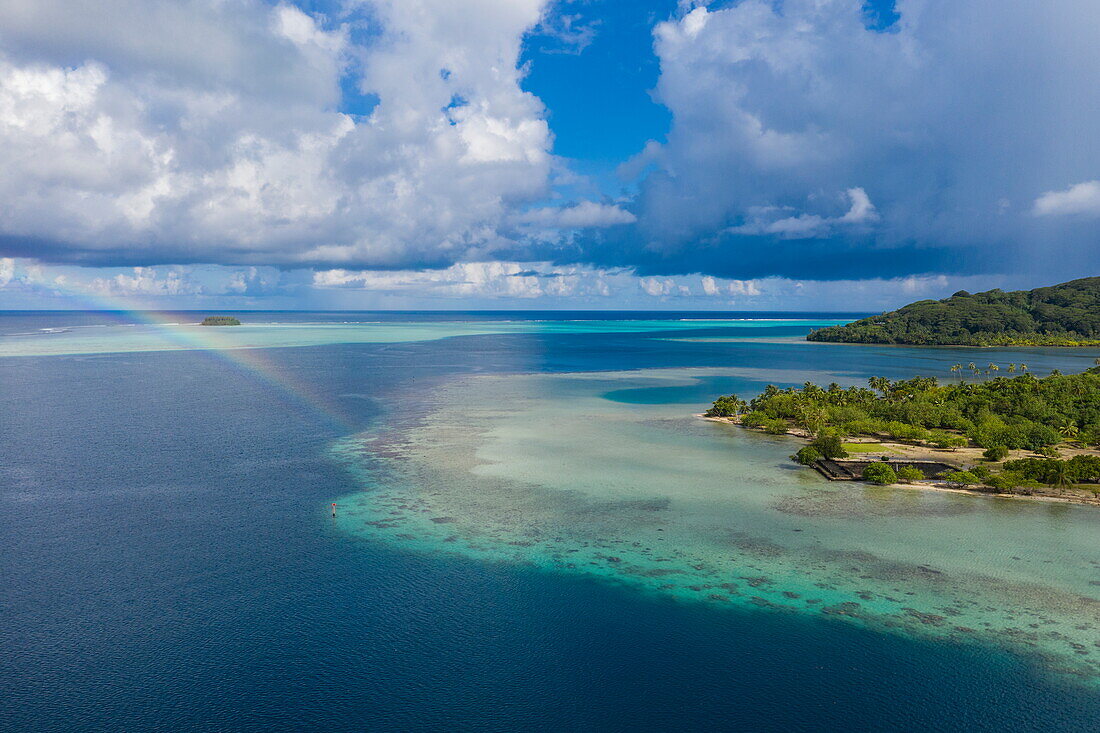  Aerial view of a rainbow on the reef near Marae Taputapuatea, Raiatea, Leeward Islands, French Polynesia, South Pacific 