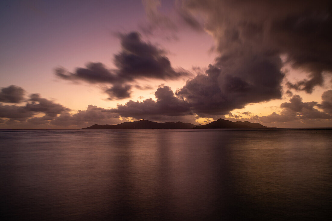  From La Digue you can see the sun setting behind the neighboring island of Praslin, La Digue, Praslin, Seychelles, Indian Ocean, Africa 