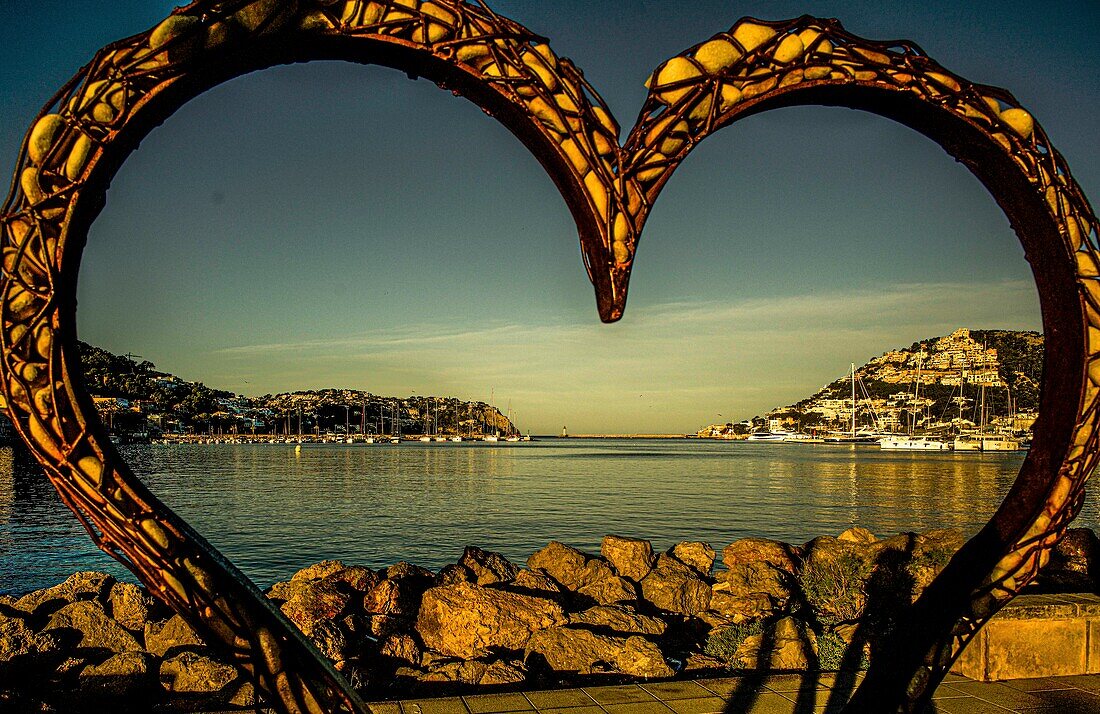  Port d´Andratx, seen in the morning light through the heart-shaped sculpture &quot;Thierro&quot; by Carlos Terroba, Mallorca, Spain 