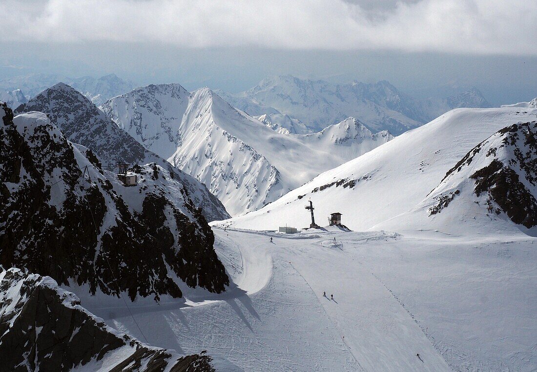 Blick gen Westen und Skifahrer auf Pisten im Gletscherskigebiet, Stubaital, Tirol, Österreich