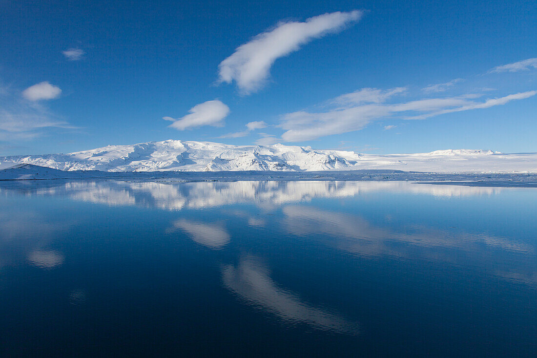  Mountain landscape reflected in the glacier lake Joekusarlon, winter, Iceland 