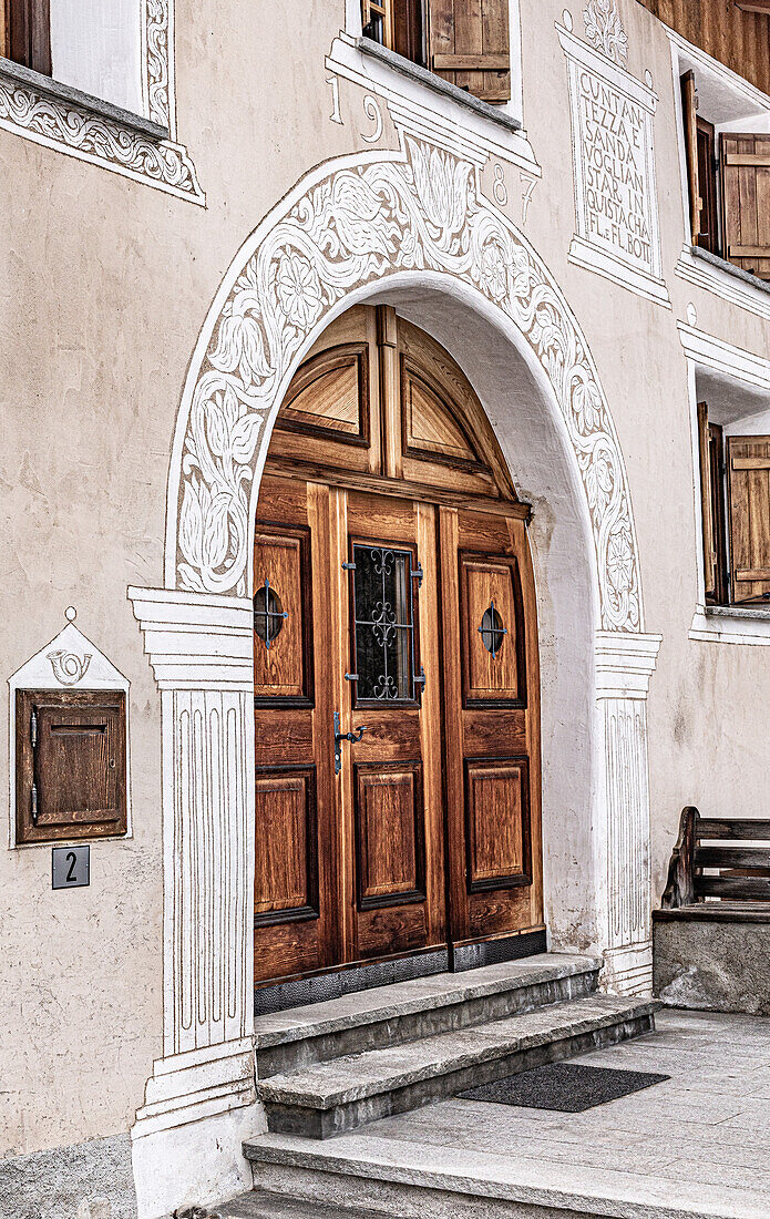   Traditional house in Valchava with sgraffito on the facade and around wooden doors and windows, Graubünden, Switzerland 