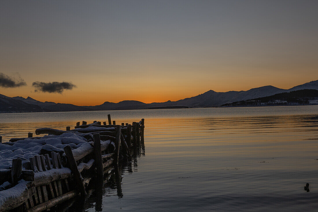  Winter in the Trömso region, Kvaloysletta, bay with old jetty in the twilight light 