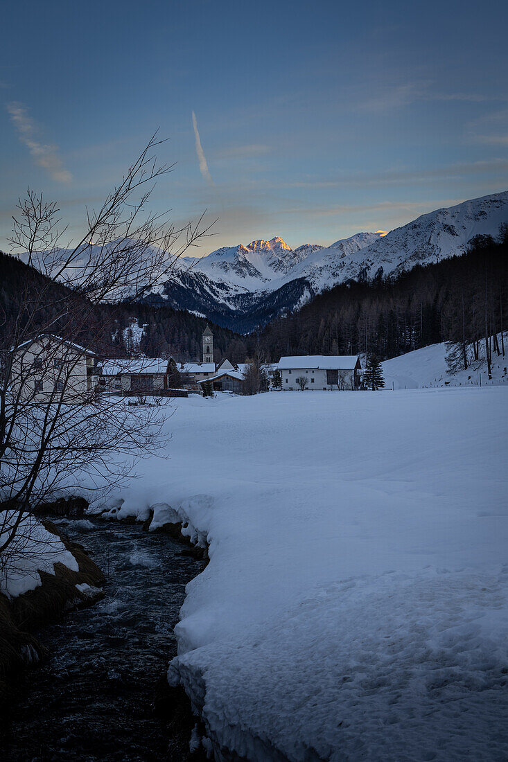  Mountain village Tschierv, Graubünden, Valmüstair, Switzerland, in winter with alpenglow. 