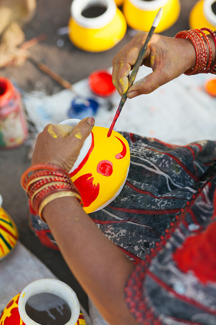 Frau aus Pune, Indien, bemalt Töpfe für das indische Fest Diwali