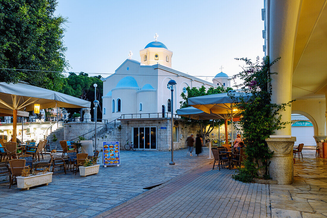  Platia Agias Paraskevis with view of the church Agia Paraskevi and arcade of the market hall in the evening in Kos Town on the island of Kos in Greece 