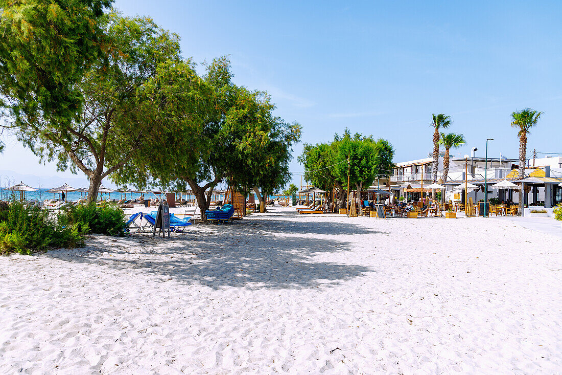 Sandstrand und Strandpromenade mit Tavernen und Cafés in Marmari auf der Insel Kos in Griechenland