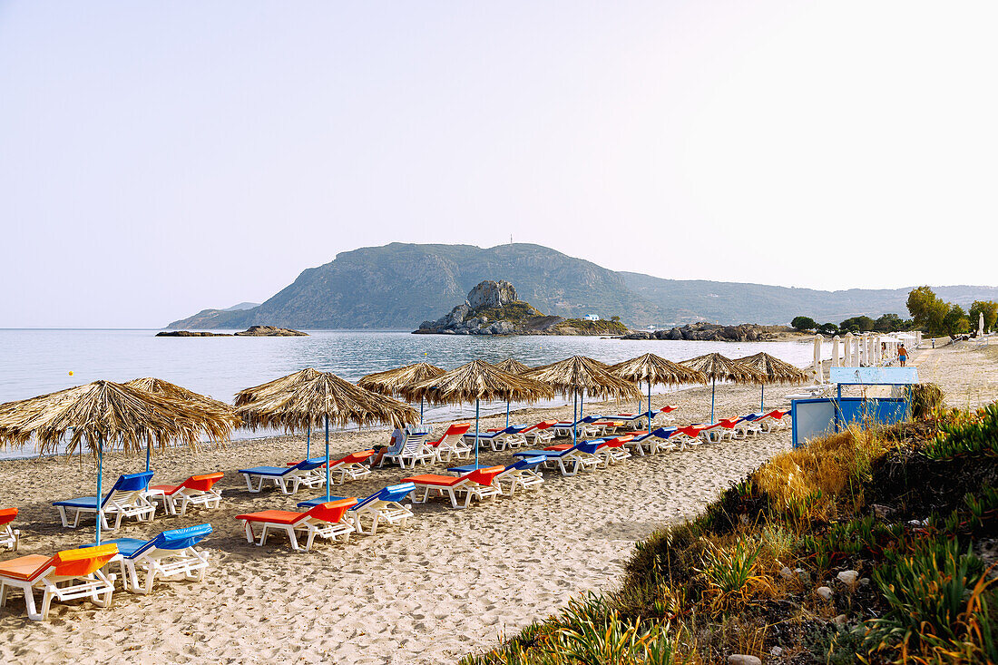 Agios Stefanos Beach mit Ausblick auf die Insel Kastri mit der Kapelle Agios Nikolaos und die Bucht von Kefalos auf der Insel Kos in Griechenland 