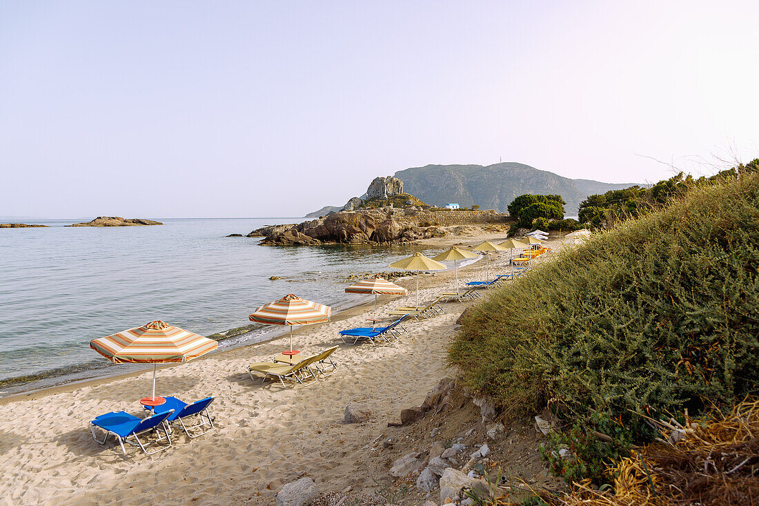 Agios Stefanos Beach mit Ausblick auf die Insel Kastri mit der Kapelle Agios Nikolaos und die Bucht von Kefalos auf der Insel Kos in Griechenland 