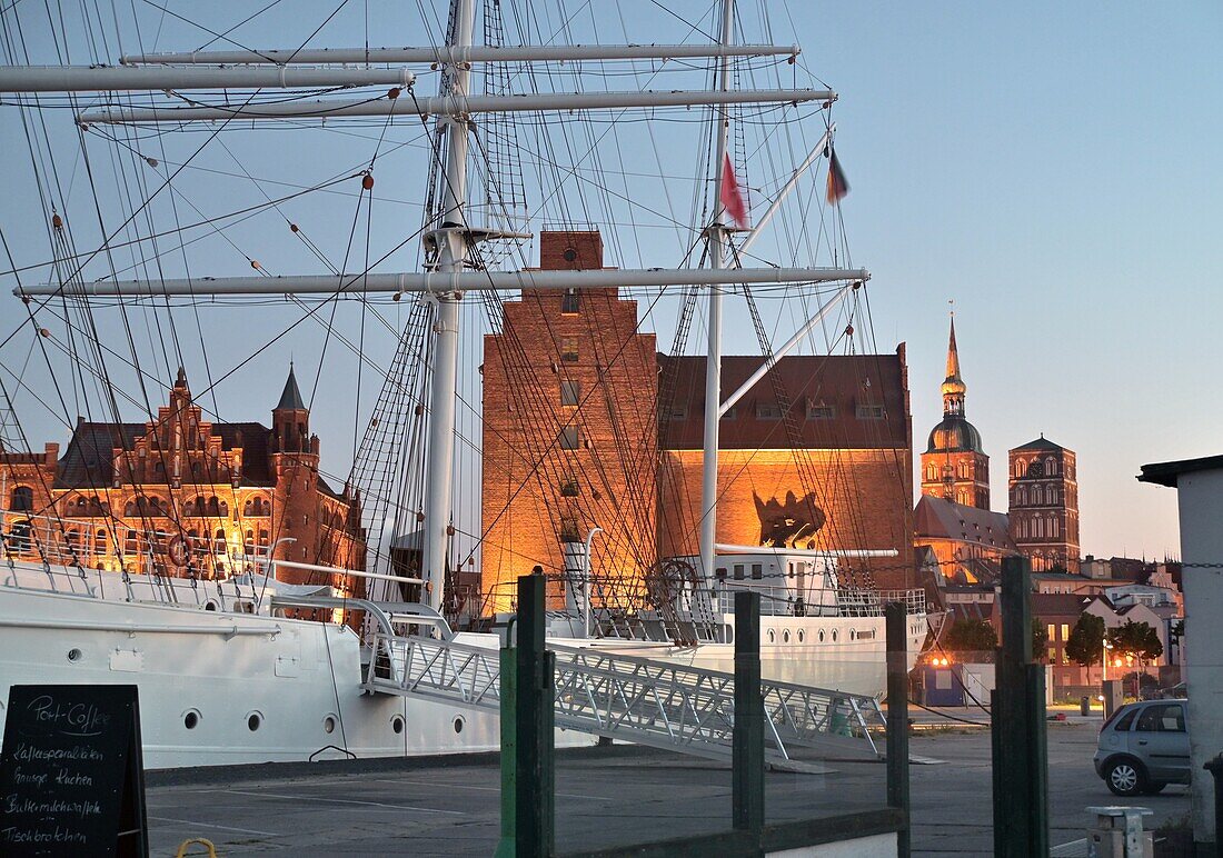 Gorch Fock Segelschiff am Hafen vor Altstadt mit Nikolaikirche bei Sonnenuntergang, Stralsund, Mecklenburg-Vorpommern, Deutschland