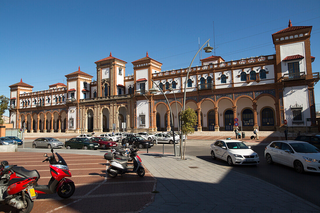 White taxi cars outside historic railway station building, Jerez de la Frontera, Spain