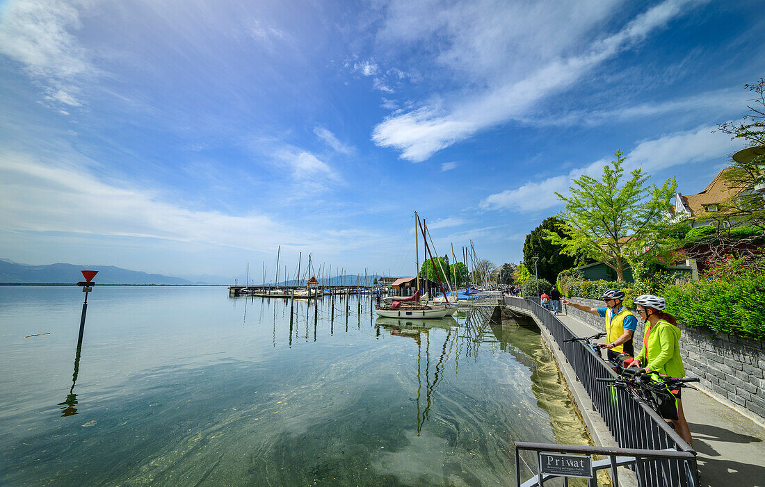  Man and woman on the Bodensee-Königssee cycle path standing on the shore of Lake Constance, Lindau, Swabia, Bavaria, Germany 