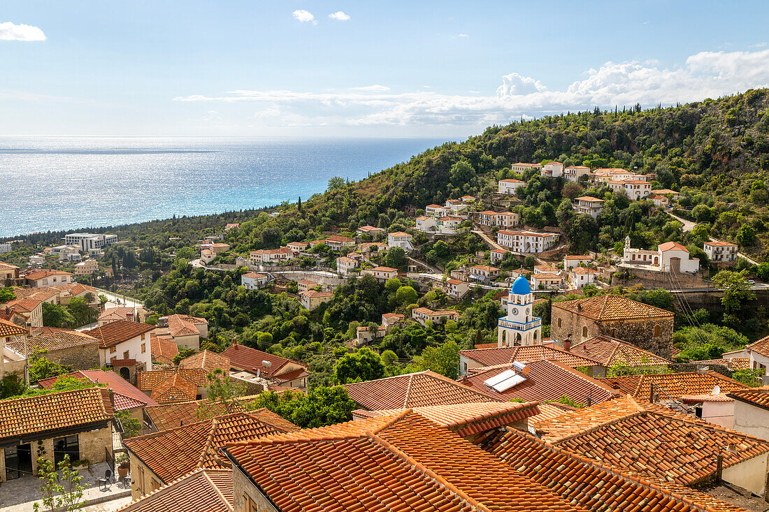 Blick auf Ionisches Meer über Häuser und Dächer mit der griechisch-orthodoxen Kirche des Heiligen Spyridon, Dorf Dhermi, Albanien