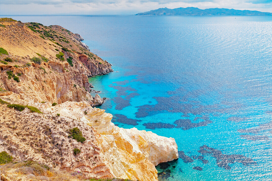 Multicoloured rock formations plunging into the sea, Firopotamos, Milos Island, Cyclades Islands, Greece