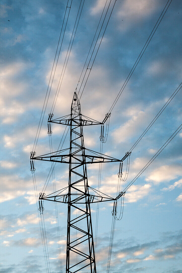 Strommast und Stromleitung gegen Himmel