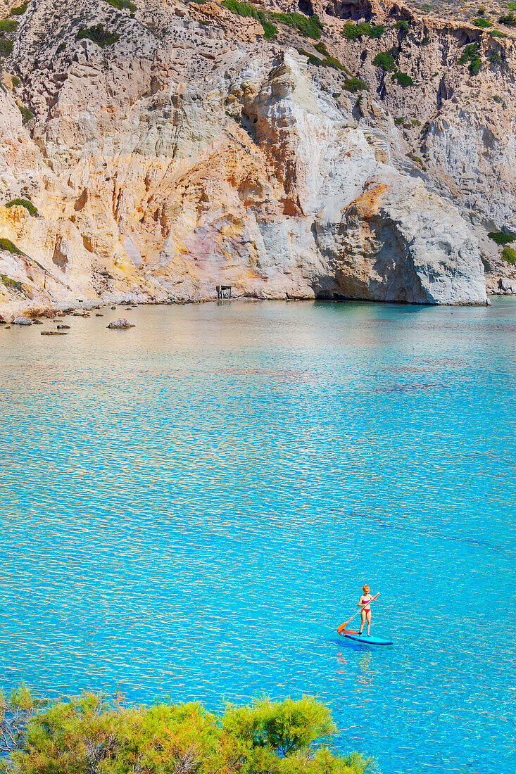 SUP, Touristisches Paddleboarding auf dem smaragdgrünen Wasser der Bucht von Firopotamos, Vogelperspektive, Firopotamos, Insel Milos, Kykladen, Griechenland