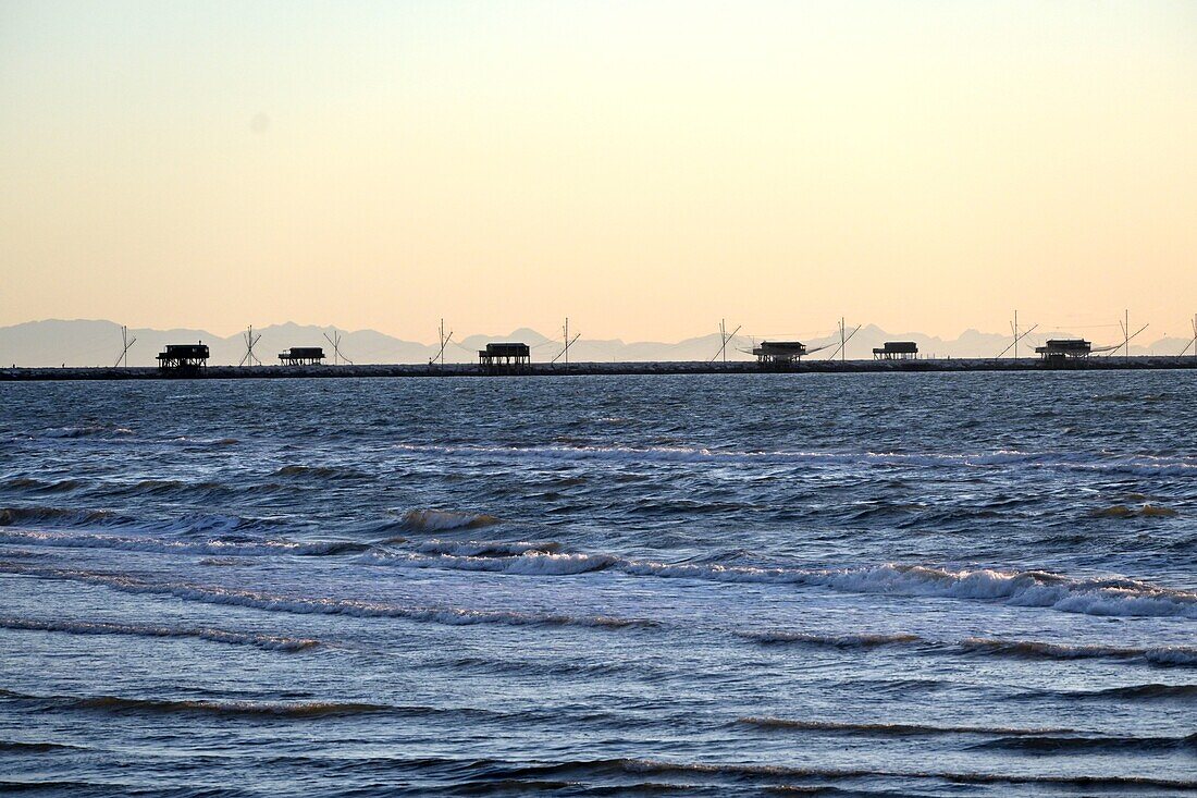 Fischerhäuser 'Casoni' an der Mole der Lagune an der Adria bei Sonnenuntergang, Sottomarina bei Chioggia, Adria, Veneto, Italien