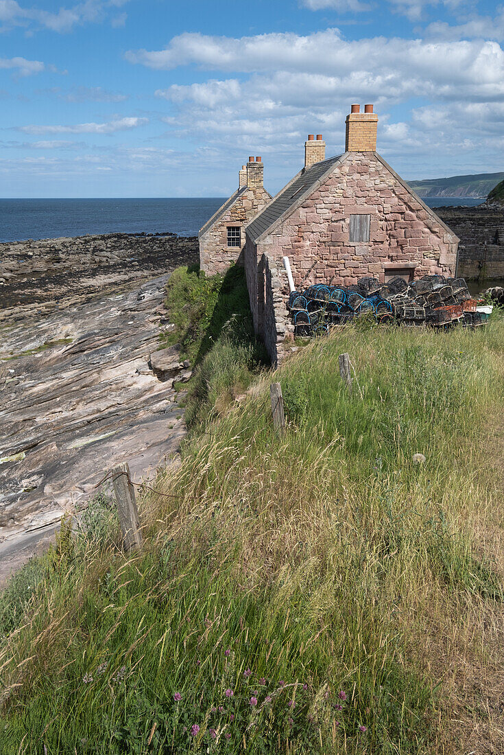  View of an old stone house in an old harbour at low tide, East Lothian, Scotland, United Kingdom 