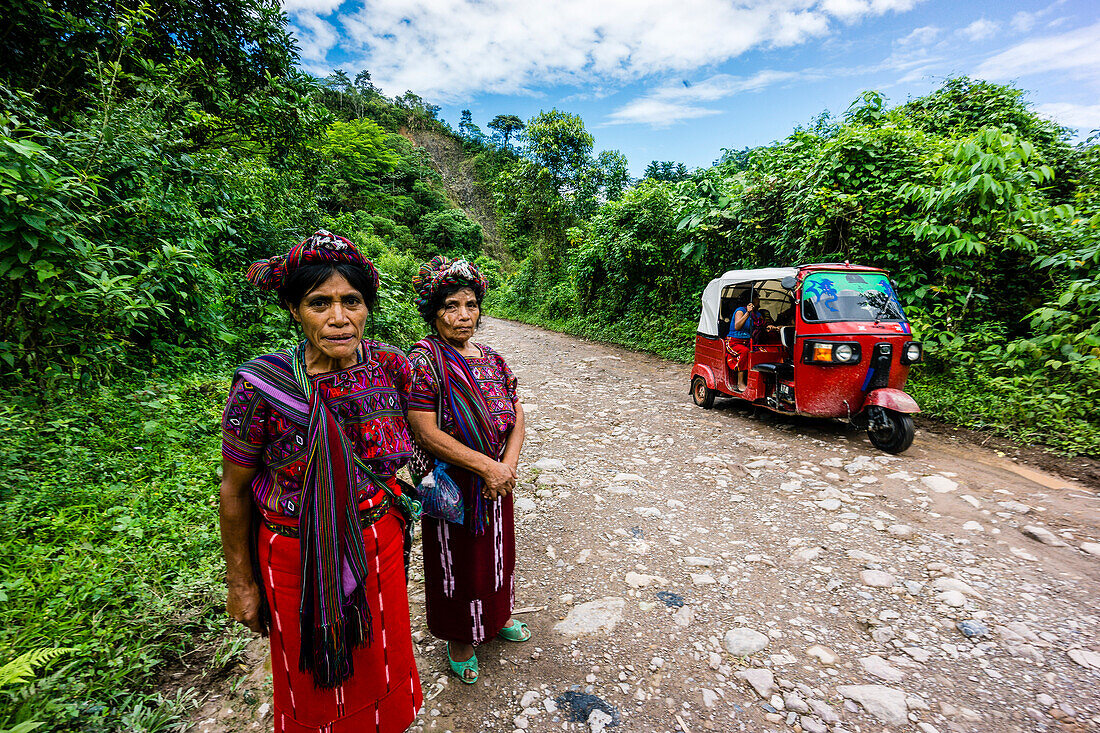 Frauen in indigener Tracht und Queqchi-Kopfbedeckung auf der Straße, Gebiet Reyna, Departement Uspantan, Guatemala, Mittelamerika