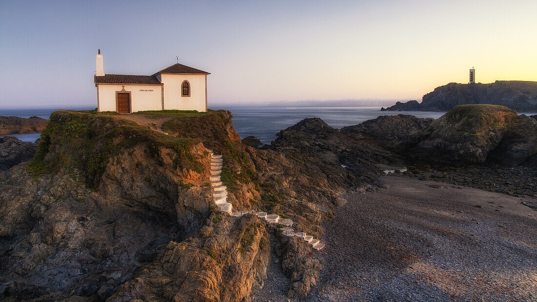 Kleine Kirche Ermita da Virxe do Porto an der Felsenküste bei Sonnenuntergang, Valdovino, A Coruña, Nordspanien, Spanien