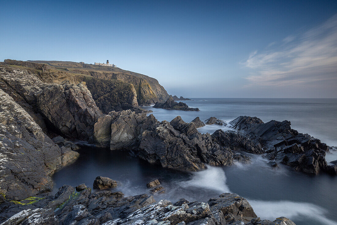  Cliffs at Sumburgh Head in Shetland. Lighthouse in the background. Blue sky. 