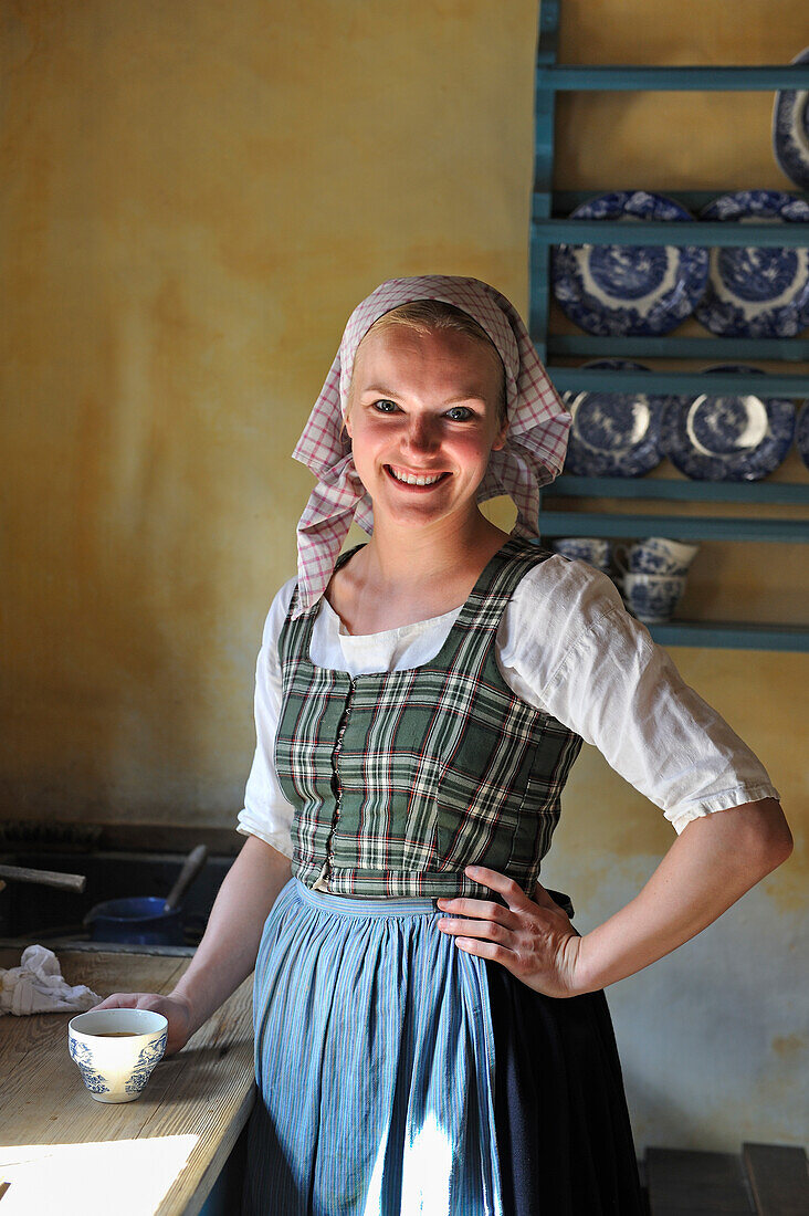 Museum staff member dress up in historical authentic clothing at Den Gamle By or The Old Town, open air town museum that consists of 75 historical buildings collected from 20 townships in all parts of the country (originally erected between 17th and 20th century), Aarhus, Jutland Peninsula, Denmark, Northern Europe