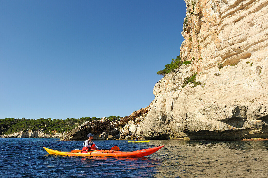 Kajak vor Klippen in der Nähe Cala Galdana, Südküste von Insel Menorca, Balearen, Spanien, Europa